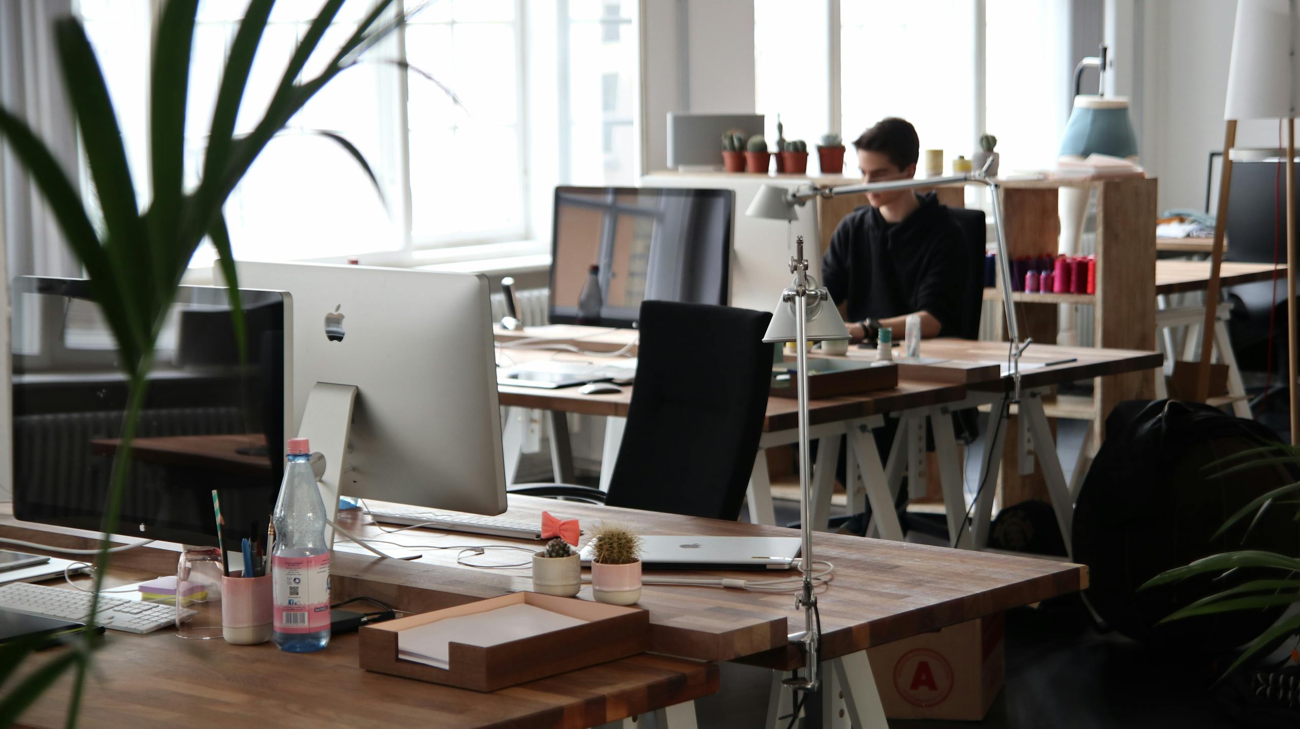 Photo by Marc Mueller Open-plan office with modern decor and natural lighting, ideal for productivity.